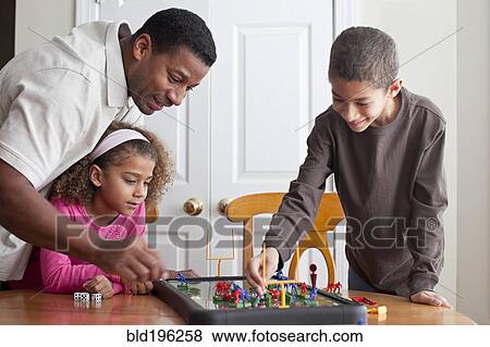 Stock Photo - Family playing board game together. Fotosearch