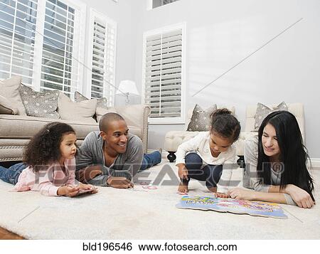 Stock Photograph - Family relaxing on living room floor. Fotosearch