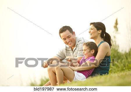 Family sitting in grass together View Large Photo Image Stock Photo - Family sitting in grass together. Fotosearch