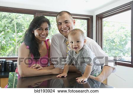 Picture - Family smiling in kitchen. Fotosearch