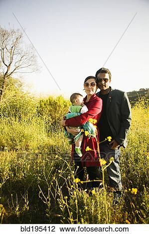 Family standing together in field View Large Photo Image Stock Image - Family standing together in field. Fotosearch