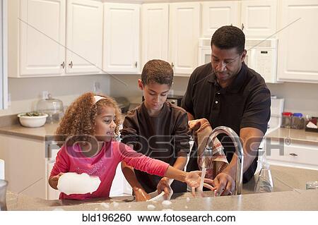 Stock Image - Family washing dishes together. Fotosearch