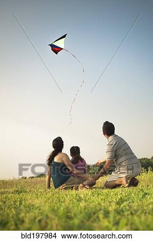 Picture - Family watching kite in sky. Fotosearch
