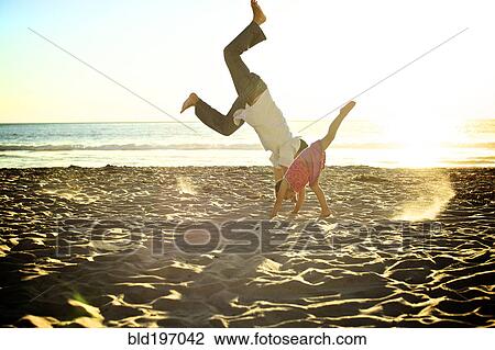 Father and daughter doing cartwheels on beach View Large Photo Image Stock Image - Father and daughter doing cartwheels on beach. Fotosearch