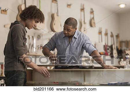 Stock Photograph - Father and son in music workshop. Fotosearch