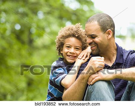 Stock Image - Father and son smiling outdoors. Fotosearch
