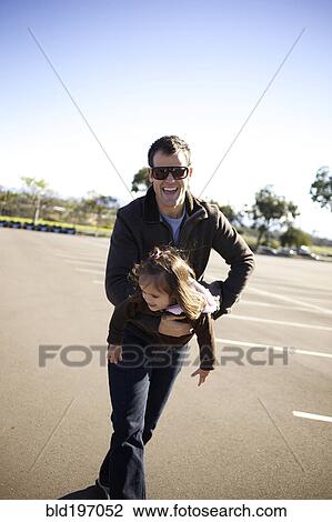 Father carrying daughter in parking lot View Large Photo Image Stock Image - Father carrying daughter in parking lot. Fotosearch