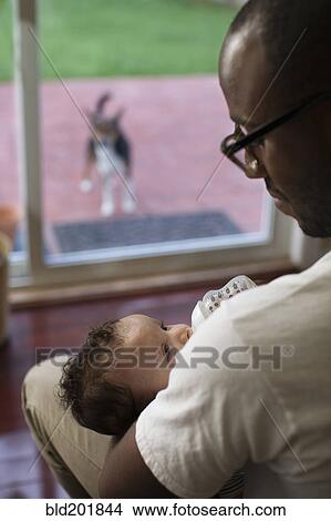 Picture - Father feeding baby. Fotosearch