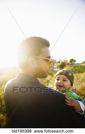 Father holding baby in field View Large Photo Image Stock Photo - Father holding baby in field. Fotosearch