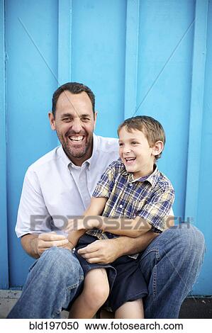 Stock Image - Father holding son on lap. Fotosearch