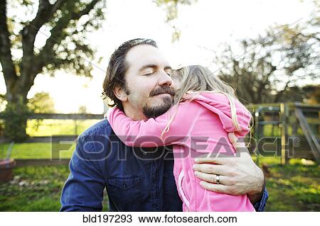 Stock Image - Father hugging daughter. Fotosearch