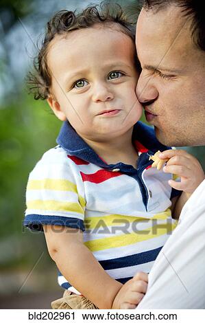Father kissing son's cheek View Large Photo Image Stock Image - Father kissing son's cheek. Fotosearch