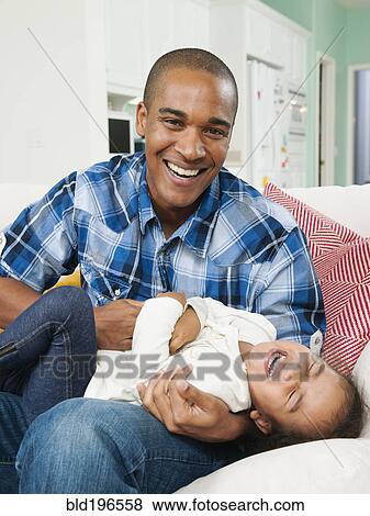 Stock Photo - Father tickling daughter. Fotosearch