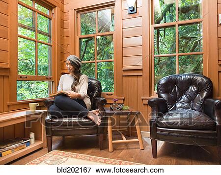 Filipino woman reading in chair View Large Photo Image Stock Photo - Filipino woman reading in chair. Fotosearch