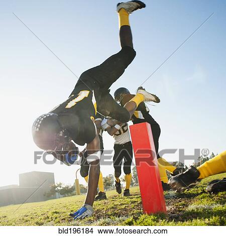 Picture - Football player scoring goal on football field. Fotosearch