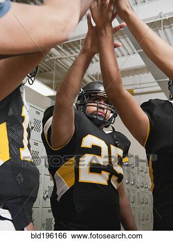 Stock Photograph - Football players celebrating in locker room. Fotosearch