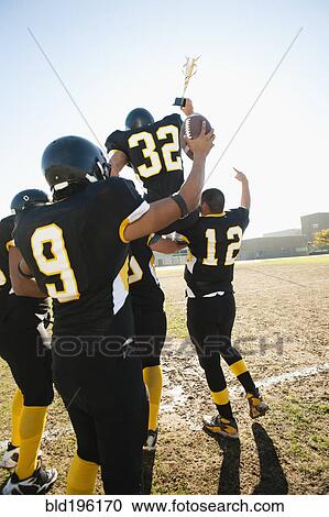 Stock Image - Football players celebrating on football field. Fotosearch