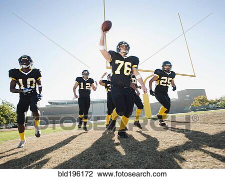 Stock Image - Football players celebrating on football field. Fotosearch