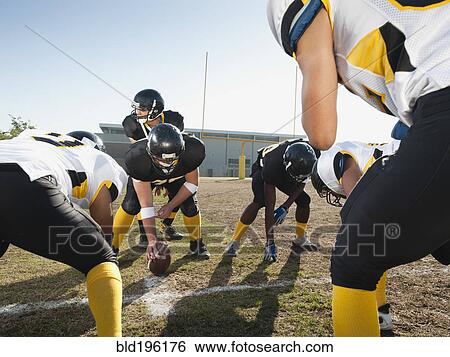 Stock Photograph - Football players crouching on football field. Fotosearch