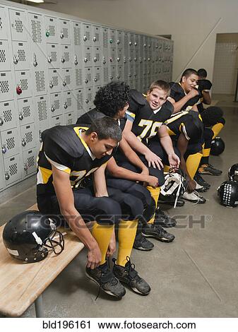 Stock Image - Football players dressing in locker room. Fotosearch