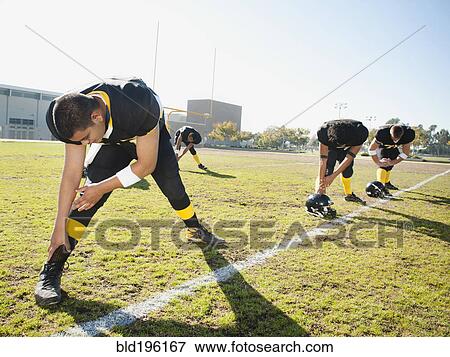 Stock Photo - Football players stretching on football field. Fotosearch