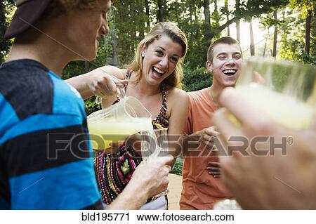 Friends hanging out together drinking lemonade View Large Photo Image Stock Image - Friends hanging out together drinking lemonade. Fotosearch