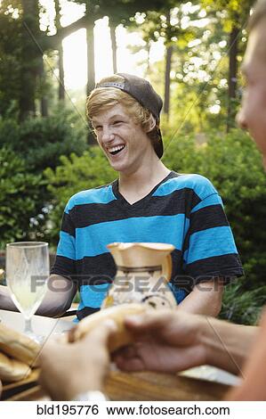 Stock Photograph - Friends hanging out together eating outdoors. Fotosearch