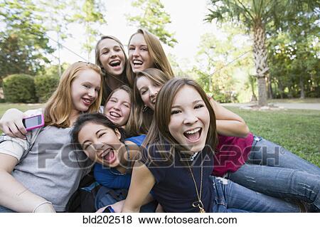 Friends hanging out together on grass View Large Photo Image Stock Photo - Friends hanging out together on grass. Fotosearch