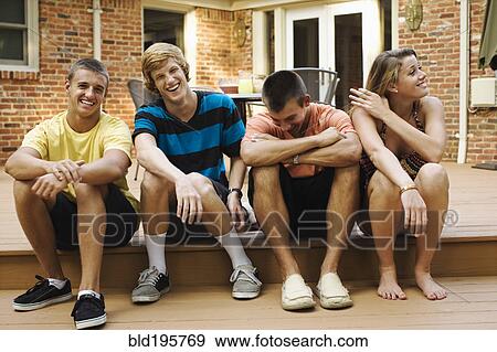 Stock Photo - Friends hanging out together on patio. Fotosearch