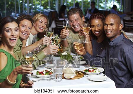 Stock Image - Friends having dinner in restaurant. Fotosearch