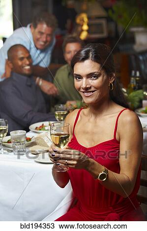Stock Image - Friends having dinner in restaurant. Fotosearch