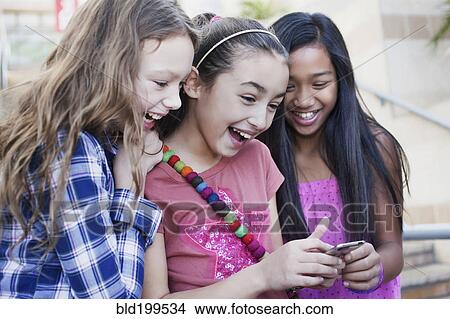 Picture - Friends looking at cell phone. Fotosearch