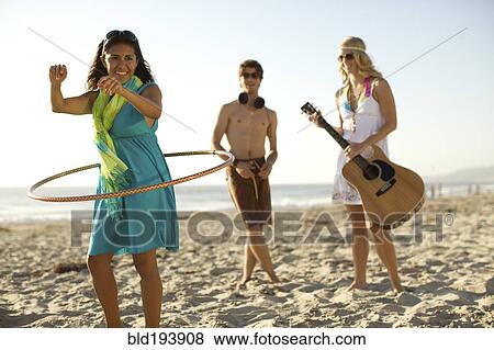 Stock Photo - Friends playing on beach. Fotosearch
