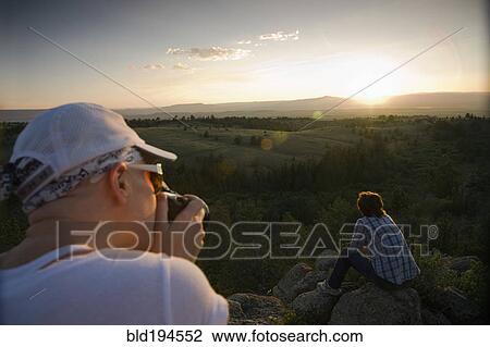 Friends resting on rocks in remote area View Large Photo Image Stock Image - Friends resting on rocks in remote area. Fotosearch