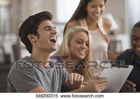 Stock Photography - Friends sharing a digital tablet. Fotosearch