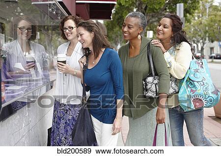 Stock Photo - Friends shopping together in city. Fotosearch