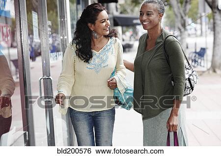 Stock Photograph - Friends shopping together in city. Fotosearch