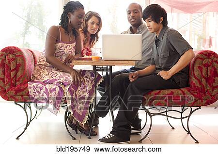 Friends sitting at laptop in cafe View Large Photo Image Stock Photo - Friends sitting at laptop in cafe. Fotosearch