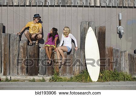 Friends sitting on posts View Large Photo Image Stock Photograph - Friends sitting on posts. Fotosearch