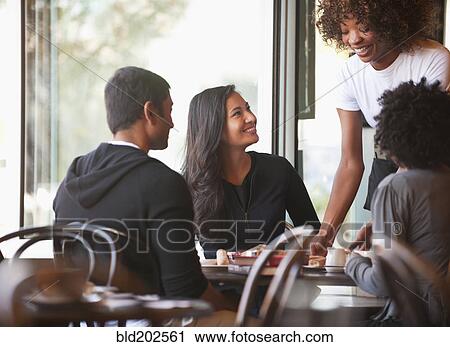 Friends sitting together in cafe View Large Photo Image Stock Image - Friends sitting together in cafe. Fotosearch