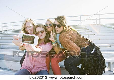 Stock Image - Friends taking self-portrait. Fotosearch