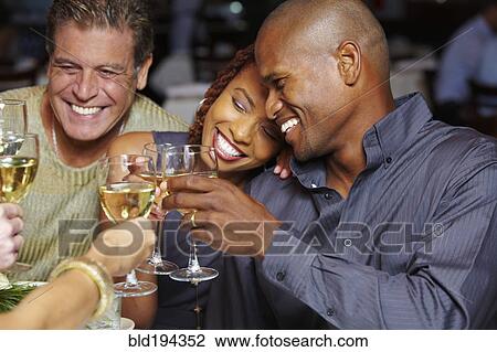 Stock Image - Friends toasting with white wine. Fotosearch