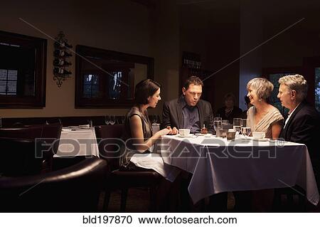 Friends watching man blow out birthday cupcake in restaurant View Large Photo Image Stock Image - Friends watching man blow out birthday cupcake in restaurant. Fotosearch