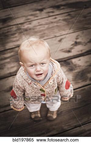 Frowning Caucasian boy standing outdoors View Large Photo Image Stock Photography - Frowning Caucasian boy standing outdoors. Fotosearch