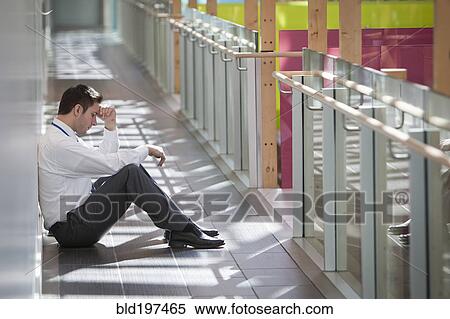 Frustrated businessman sitting on office corridor floor View Large Photo Image Stock Photography - Frustrated businessman sitting on office corridor floor. Fotosearch