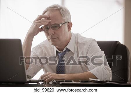Frustrated Caucasian businessman using laptop at desk View Large Photo Image Stock Image - Frustrated Caucasian businessman using laptop at desk. Fotosearch
