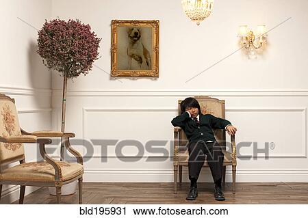 Frustrated Vietnamese boy sitting on elegant chair View Large Photo Image Stock Image - Frustrated Vietnamese boy sitting on elegant chair. Fotosearch