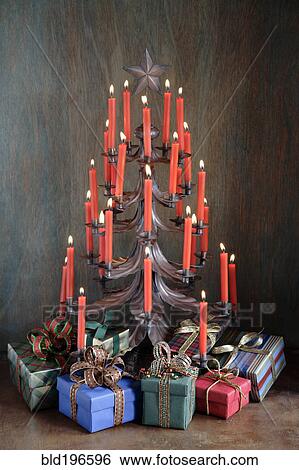 Stock Photograph - Gifts under candle Christmas tree. Fotosearch
