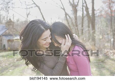 Stock Photography - Girlfriends laughing and hugging. Fotosearch
