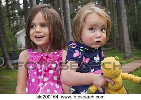 Picture - Girls standing together in forest. Fotosearch